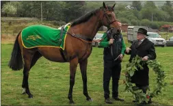  ?? All photos by John Delea ?? President Michael D. Higgins presents a wreath to ‘Butler Cabin’ belonging to JP McManus to honor hero horses in Irish culture at the Féile na Laoch Festival in Coolea, just after sunrise on Wednesday.