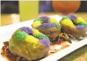  ?? PHOTOS BY GERALD HERBERT/AP ?? King-cake doughnuts, served with strawberry jam and toasted pecans, come in Mardi Gras colors at Emeril's Delmonico in New Orleans.