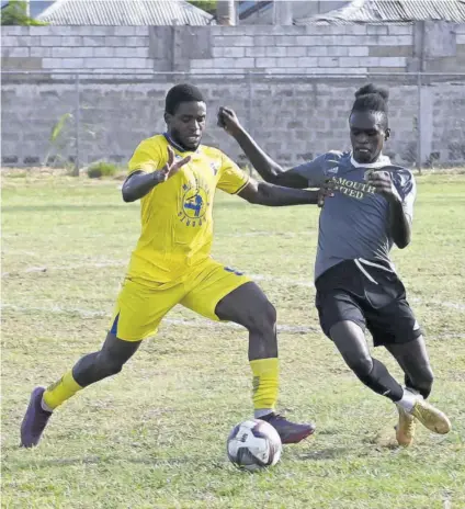  ?? (Photo: Paul Reid) ?? Racing United’s Raheem Edwards (left) takes on Falmouth United’s Phelon Christie in their JFF Tier II game at Elleston Wakeland Centre on May 3. Both players had scored in the game that had ended 3-3.