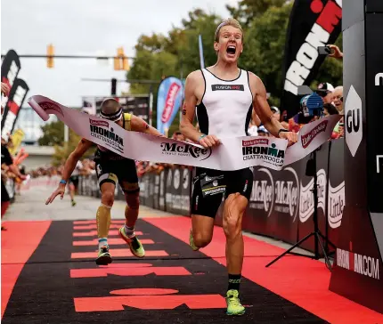  ?? STAFF PHOTOS BY DOUG STRICKLAND ?? Kirill Kotsegarov, right, crosses the finish line 2 seconds ahead of Matt Chrabot to win Ironman Chattanoog­a on Sunday. Stefan Schmid finished third in the triathlon, just 8 seconds behind Chrabot.