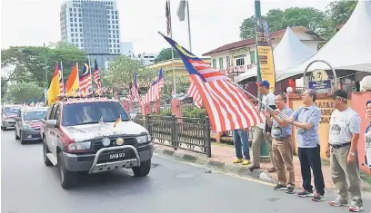  ??  ?? SELAMAT BERKONVOI: Fadillah bersama Shukarmin (kanan) dan Ali (kiri) melakukan pelepasan para peserta Konvoi Kembara Merdeka Negaraku di Kuching semalam.