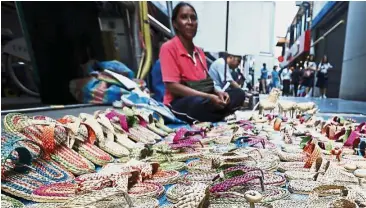  ?? — EPA ?? Strong exports: A file picture showing a woman selling handmade sandals at a street in Bangkok. Strong exports drove Thailand’s Q2 GDP to grow 3.7% on a yearly basis.