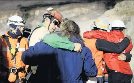  ?? Hugo Infante Associated Press ?? RESCUED MINER Florencio Avalos, second from left, hugs a relative after emerging from the collapsed gold and copper mine.