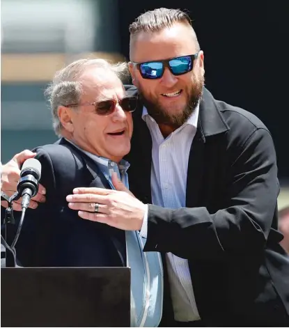  ??  ?? Former Sox pitcher Mark Buehrle hugs chairman Jerry Reinsdorf during a ceremony to retire Buehrle’s No. 56 on Saturday. | AP