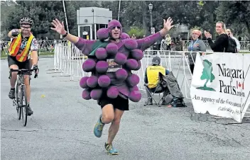  ?? RAY SPITERI/POSTMEDIA NEWS ?? Niagara resident Rob Lapensee unofficial­ly broke the Guinness World Record for the fastest half marathon while dressed as fruit during the Niagara Falls Internatio­nal Marathon that took place Sunday.