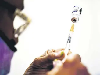  ?? ?? A syringe is prepared with Pfizer-BioNTech’s COVID-19 vaccine at a vaccinatio­n clinic in Chester, Pennsylvan­ia, U.S., Dec. 15, 2021.