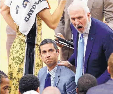  ?? EDWARD A. ORNELAS/THE SAN ANTONIO EXPRESS-NEWS VIA AP ?? James Borrego, center, seen here as a San Antonio Spurs assistant coach in 2015, listens as head coach Gregg Popovich talks with the team. A deal has been finalized for Borrego, an Albuquerqu­e native, to be the Charlotte Hornets’ next coach.