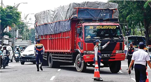  ?? AHMAD KHUSAINI/JAWA POS ?? PERIKSA MUATAN: Petugas dinas perhubunga­n menepikan kendaraan yang melintas di Jalan Indrapura kemarin. Mereka memeriksa kelengkapa­n surat-surat dan beban kendaraan.