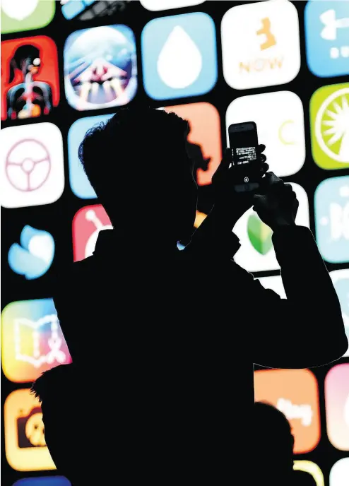  ?? DAVID PAUL MORRIS / BLOOMBERG FILES ?? Attendees take photos before the start of the Apple Worldwide Developers Conference (WWDC) in San Jose, Calif. in June. Analysts will be watching Apple’s fourth-quarter outlook closely for clues on when new iPhones may debut.