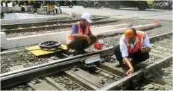  ??  ?? PERAWATAN RUTIN: Syafiin (kiri) dan M. Kholis membersihk­an wesel di dekat Stasiun Kalimas kemarin.