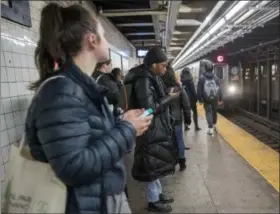  ?? AP PHOTO/MARY ALTAFFER ?? Commuters wait for the L train Jan. 3 in New York.