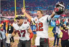  ?? STEVE LUCIANO/ASSOCIATED PRESS ?? Tampa Bay Buccaneers tight end Rob Gronkowski (87) and quarterbac­k Tom Brady celebrate after the Bucs’ Super Bowl 55 win. Brady is recovering from offseason knee surgery and expects to be ready for June minicamp.