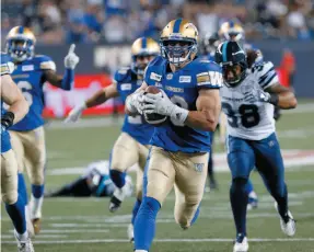  ?? CP PHOTO ?? Winnipeg Blue Bombers player Ian Wild runs in a blocked kick for a touchdown during a game against the Toronto Argonauts in Winnipeg on Friday.