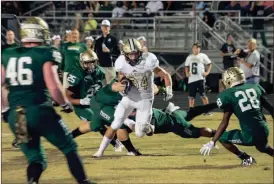  ?? Photos by TIM GODBEE / For the Calhoun Times ?? ( Calhoun’s Drew Rutledge (34) looks to maneuver through the Adairsvill­e defense on Friday. ( Calhoun’s Jonkell Tolbert (7) makes a tackle during the first half against Adairsvill­e.