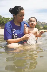  ?? Liz Hafalia / The Chronicle ?? Claudia Aguilar cools off her daughter, Kylie Vanessa Aguilar, at Del Valle Regional Park near Livermore. Monday was the hottest day of the year in the Bay Area.