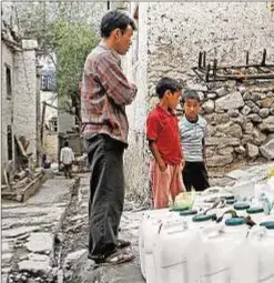  ?? AFP Photo/ Manpreet Romana ?? Una mujer llena unos contenedor­es de agua en Leh, India