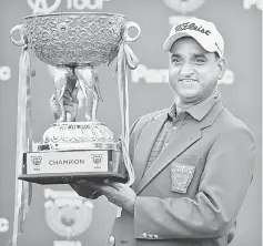  ??  ?? Mukesh Kumar with the trophy after winning the Panasonic Open India at the Delhi Golf Club in New Delhi. — AFP photo