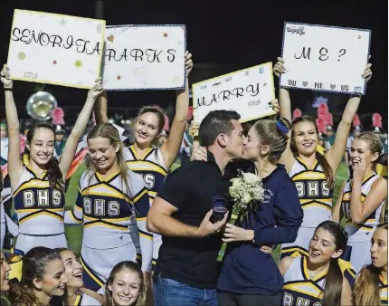  ?? R. BENNETT / THE PALM BEACH POST BRUCE ?? Zac Trahan and Emily Parks kiss during a half-time proposal at a high school football game between Atlantic and Boca Raton on Oct. 27.