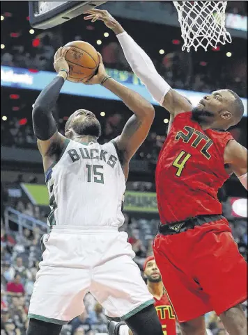  ?? CURTIS COMPTON / CCOMPTON@AJC.COM ?? Paul Millsap blocks a shot by the Bucks’ Greg Monroe on Sunday during the Hawks’ easy home win.