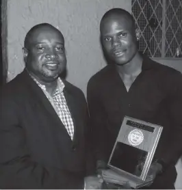  ??  ?? Shemeah Mushiribin­di gets his award from Zimbabwe Rugby Referees president Gerald Chipumha