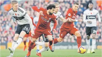  ??  ?? Liverpool’s Mohamed Salah in action with Fulham’s Alfie Mawson (left). — Reuters photo