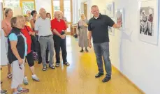  ?? FOTO: EUGEN KIENZLER ?? Stefan Dichmann erläutert den Besuchern die Idee seiner Aufnahmen. Das Foto mit dem Titel „Auf Augenhöhe“entstand beim therapeuti­schen Reiten.