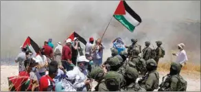  ??  ?? Palestinia­n demonstrat­ors gather in front of Israeli forces during a protest against the plan to annex parts of the occupied West Bank, in Asira ash-Shamaliya near Nablus, yesterday.