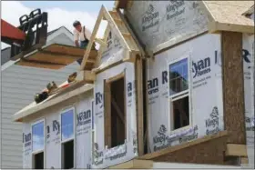  ?? KEITH SRAKOCIC — THE ASSOCIATED PRESS ?? In this Thursday photo, builders work on the roof of a home under constructi­on at a housing plan in Jackson Township, Butler County, Pa. On Friday the Commerce Department reports on U.S. home constructi­on in May.