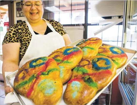  ??  ?? ABOVE: Mary Quintana holds a tray
of Día de los Muertos pan dulce at Panaderia Zaragoza on Tuesday.