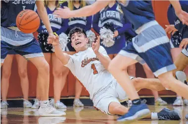  ?? ROBERTO E. ROSALES/JOURNAL ?? Eldorado’s Tyler Quintana passes the ball as he falls during the Eagles’ win over La Cueva on Friday. Quintana scored 38 points as the Eagles moved into first place in District 2-5A, ahead of the Bears.