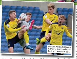  ??  ?? Burton Albion’s Hayden Carter is surrounded as he tries to win the ball.
