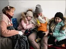  ?? Evgeniy Maloletka / Associated Press ?? Women and children sit on the floor of a corridor in a hospital in Mariupol, eastern Ukraine.