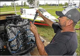  ?? BILL LACKEY / STAFF ?? Keven McCollough from Beaumont, Texas, works on the engine of one of his boats at the Clark County Fairground as he gets them ready for the Wake the Lake F1 Grand Prix boat races this weekend.