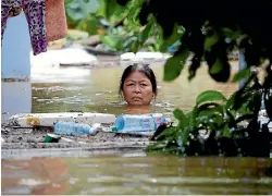  ?? KHAM ?? A woman wades through a submerged street at the Unesco heritage ancient town of Hoi An after typhoon Damrey hit Vietnam.