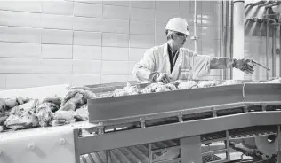  ?? Associated Press file photo ?? A worker operates a conveyor belt at a Nebraska meatpackin­g plant. With Labor Day approachin­g, retailers are in bidding wars to secure packaged meat for their holiday store promotions.