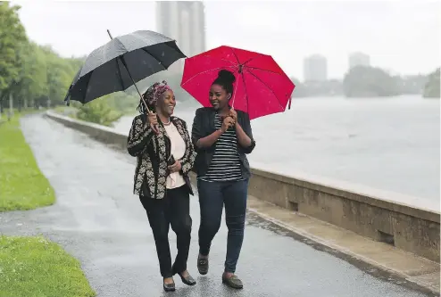  ?? DAVE CHAN / THE NEW YORK TIMES ?? Justine Nkurunziza, left, and Tabitha Mukamusoni, asylum seekers from Burundi, walk along the Rideau River in Ottawa last week. Canada is the final stop in many refugees’ desperate journey to escape the summary executions, assassinat­ions and torture...