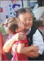  ?? ZOU HONG / CHINA DAILY ?? Pan Yulian hugs a Uygur student after class.