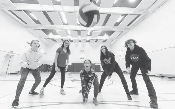  ?? MICHAEL BELL ?? Tyler Graham, Tavah Delorme, Adrienne Sagun, Aaliyah Chartrand and Alex McDonald return some serves in the gym at Holy Rosary Community School. The team from the small school of just 135 students won the Regina Catholic School Division’s girls...