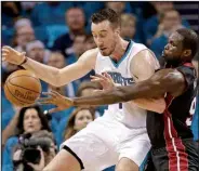  ?? AP/CHUCK BURTON ?? Miami defender Luol Deng (right) knocks the ball away from Charlotte center Frank Kaminsky in the first half. The Heat had lost three games in a row in the series before Friday’s victory.