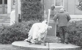  ?? JESSICA ANDERSON/BALTIMORE SUN ?? A work crew prepares to move the statue of Roger B. Taney from the front of City Hall in Frederick. It will be relocated to Mount Olivet Cemetery in the city.