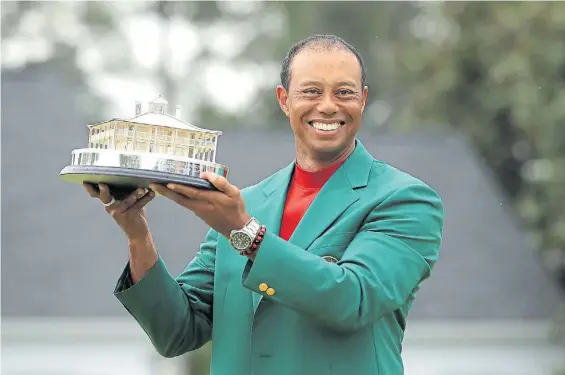  ??  ?? Campeón. Tiger y el trofeo de Augusta, ya con el clásico saco verde. Ganó cinco veces el torneo y lleva 15 Grand Slam, a solo tres de Jack Nicklaus.