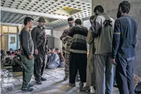 ?? IVOR PRICKETT/THE NEW YORK TIMES ?? Men suspected of fighting for the Islamic State are searched at a security screening center last week near Kirkuk, Iraq.