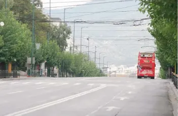  ??  ?? Οι δρόμοι της Αθήνας αδειάζουν τον Αύγουστο, σε σημείο που οι πεζοί βολτάρουν πολλές φορές αμέριμνοι στη μέση τους. Εξαίρεση αποτελούν τα χαρακτηρισ­τικά κόκκινα τουριστικά λεωφορεία.