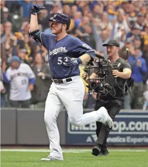  ?? MARK HOFFMAN / MILWAUKEE JOURNAL SENTINEL ?? Reliever Brandon Woodruff gets the Brewers on the board with a homer run in the third inning Friday night.