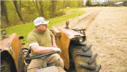  ??  ?? Matt Jones sits on his tractor as he works on the farm Saturday.