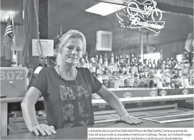  ??  ?? La dueña de la cantina Gabrielle Ellison de Big Daddy Zane que posa detrás de la barra de su establecim­iento en Odessa, Texas, se molestó luego autoridade­s ordenaron cerrar los bares y cantinas por la pandemia.