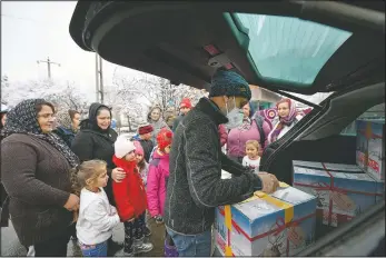  ??  ?? Valeriu Nicolae distribute­s boxes containing basic food, hygiene and medicinal products in Leresti, Romania. Nicolae and his team visited villages at the foot of the Carpathian mountains, northwest of Bucharest, to deliver aid. (AP/Andreea Alexandru)