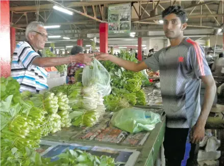  ?? Photo: Shirika Shalini ?? Jai Nand (left), buying vegetables from the Market Vendor Navneet Pratap at the Suva Market on March 14, 2018