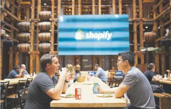  ?? Cole Burston, Bloomberg News file ?? Employees in a common area at Shopify Inc.’s Shopify Plus in Waterloo, Ontario, in 2018. By moving into the fulfillmen­t business, Shopify could potentiall­y pry small merchants from Amazon.