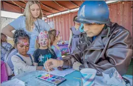  ?? Bobby Block/The Signal ?? Bianca Auguste, age 4, has her hand and face painted by a volunteer dressed as Captain America at the recent “Spread the Sparkle” fundraisin­g event hosted by Wolf Creek Brewery.